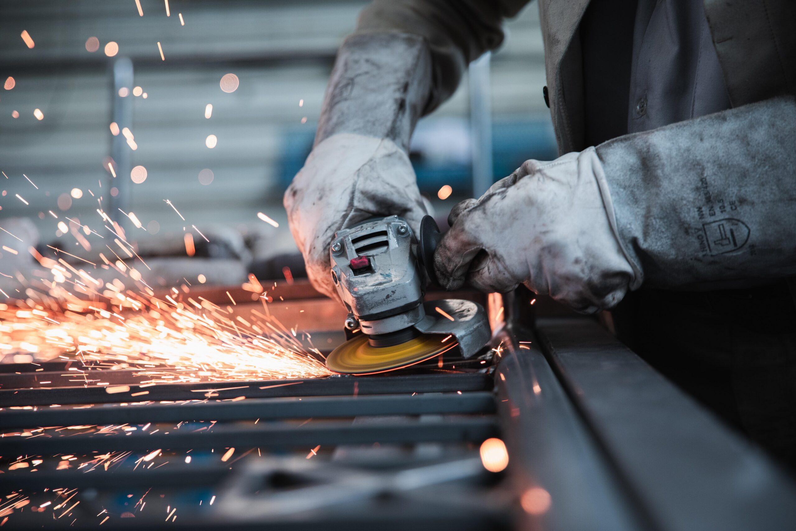 Close-up of worker using angle grinder on steel