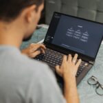 Man using laptop with AI interface, typing with focused attention.