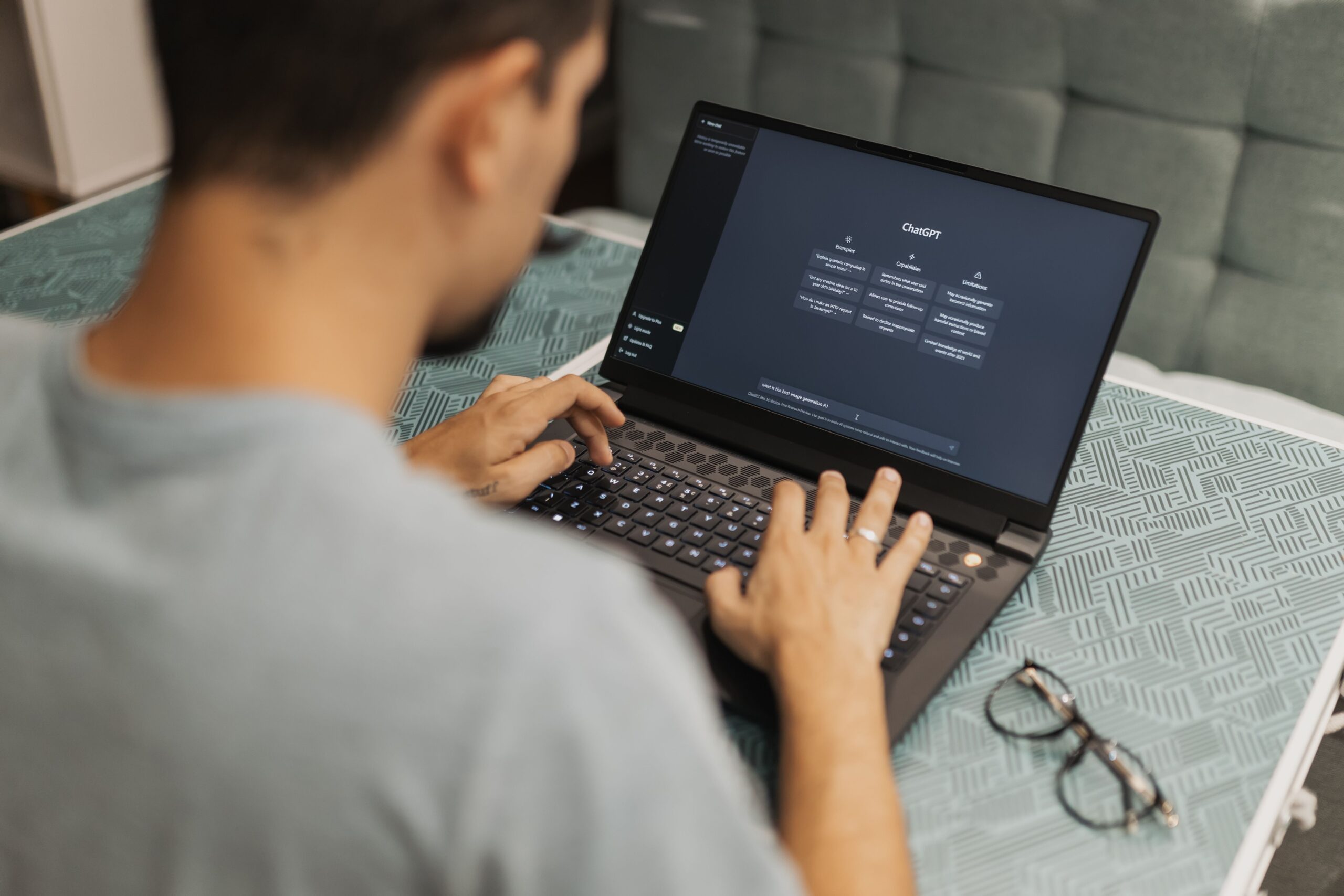 Man using laptop with AI interface, typing with focused attention.