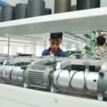 Industrial textile factory interior with workers operating machinery