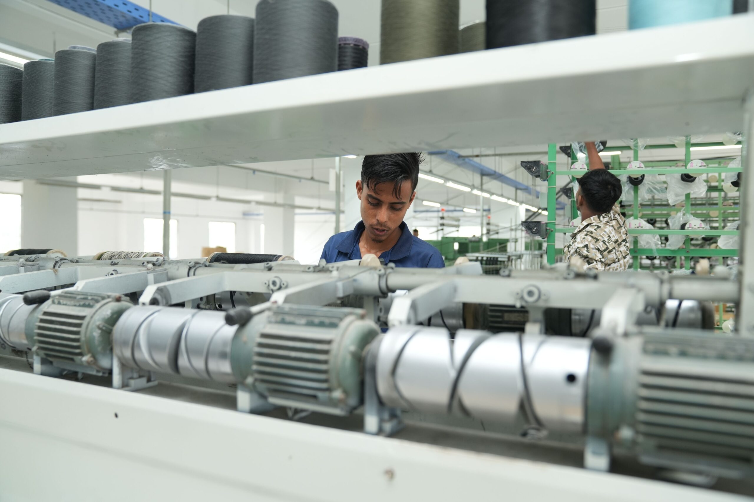 Industrial textile factory interior with workers operating machinery