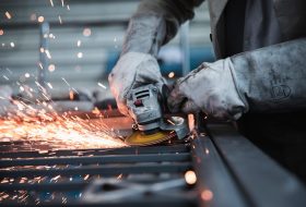 Close-up of worker using angle grinder on steel
