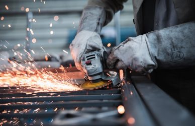 Close-up of worker using angle grinder on steel