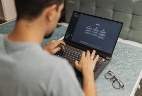 Man using laptop with AI interface, typing with focused attention.