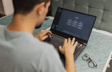 Man using laptop with AI interface, typing with focused attention.