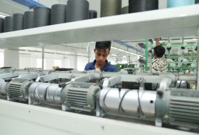 Industrial textile factory interior with workers operating machinery