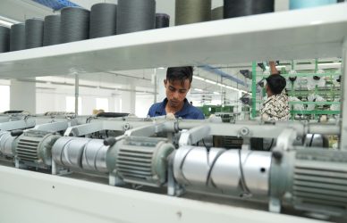 Industrial textile factory interior with workers operating machinery