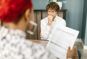 Man reflecting during a job interview in an office setting