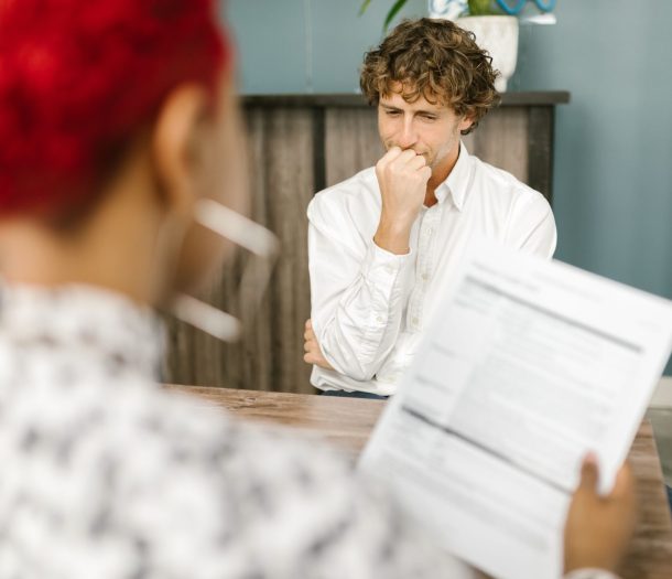 Man reflecting during a job interview in an office setting