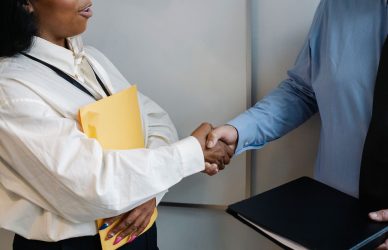 Two professionals shaking hands in an office setting