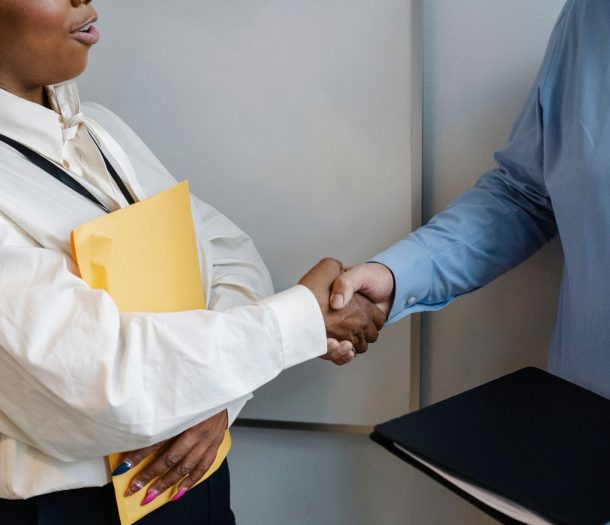 Two professionals shaking hands in an office setting